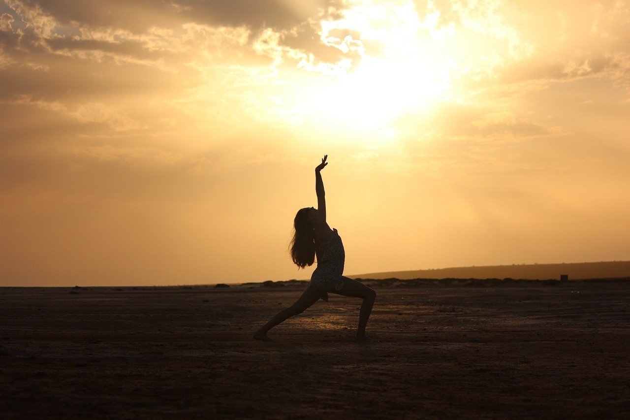 Silhouette of a girl dancing in front of the sunset